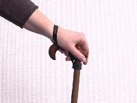 Attaccate la cinghia da polso sul vostro bastone da passeggio usando la banda di Velcro.