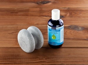 Natural Hukka massage stone against stress and contractions, together with massage oil