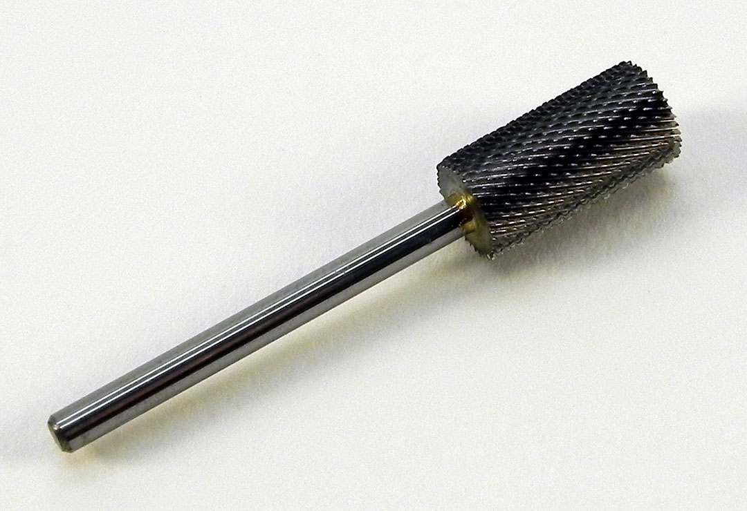 Punta in metallo duro argento a forma di grosso cilindro. La punta a grana fine può essere usata per diversi lavori sulle unghie artificiali. 